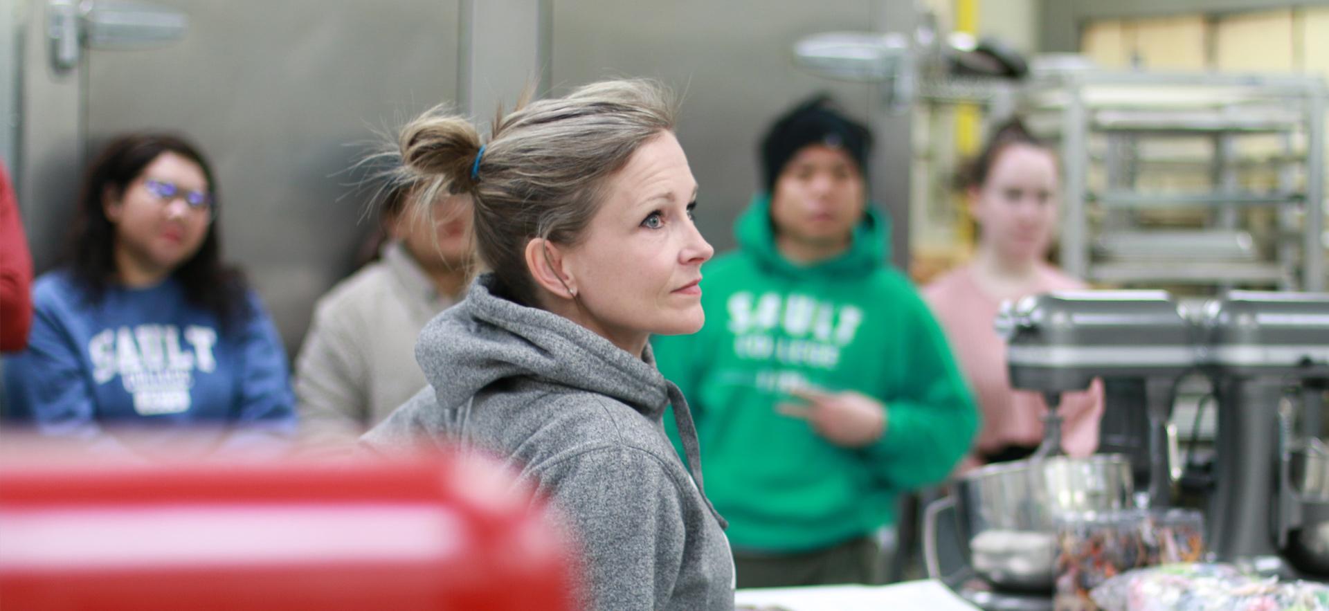 Business instructor in lab with entrepreneurship class preparing to manufacture products