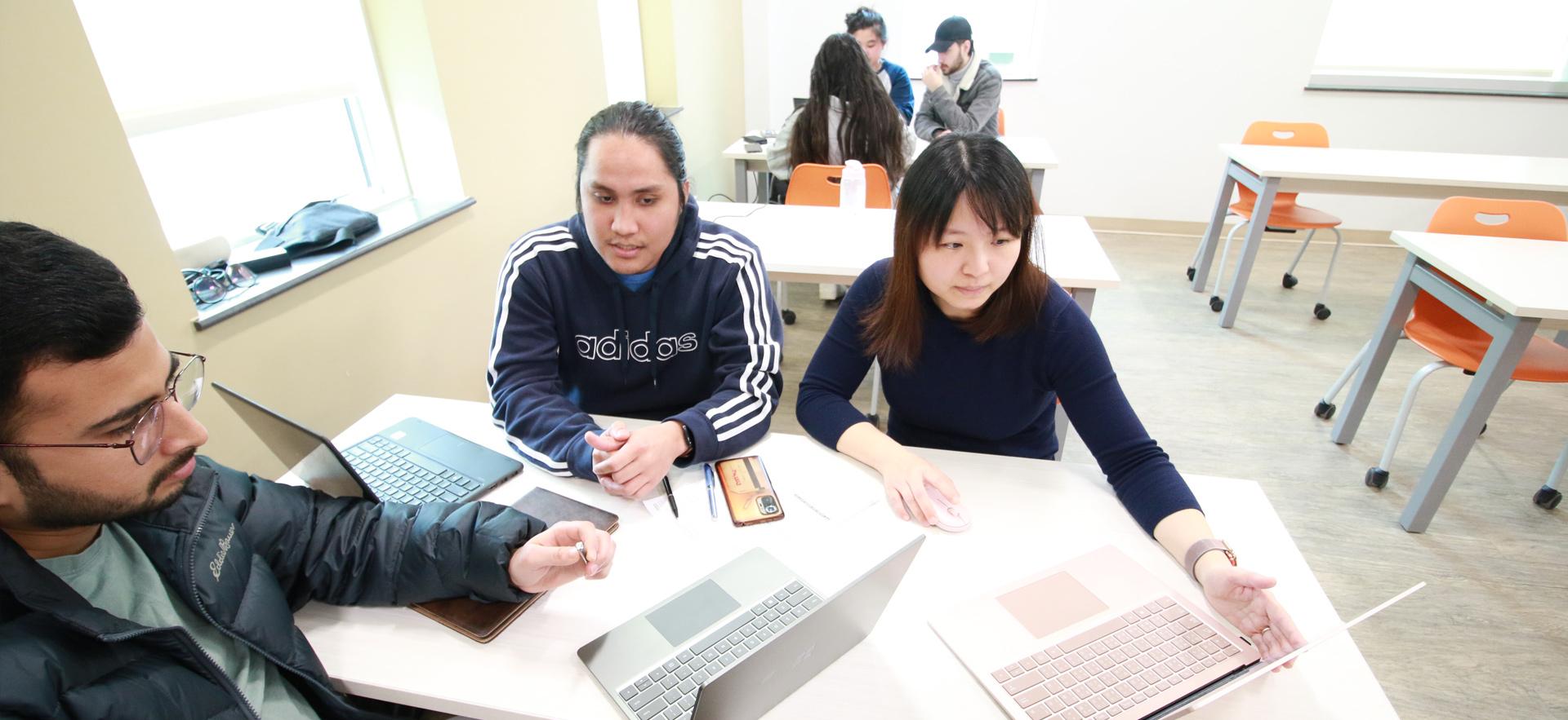 Business - Accounting students on computers in class helping a student at the Tax Clinic