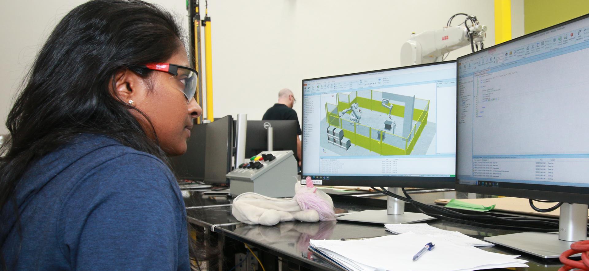 Engineering student working on computers in robotics lab