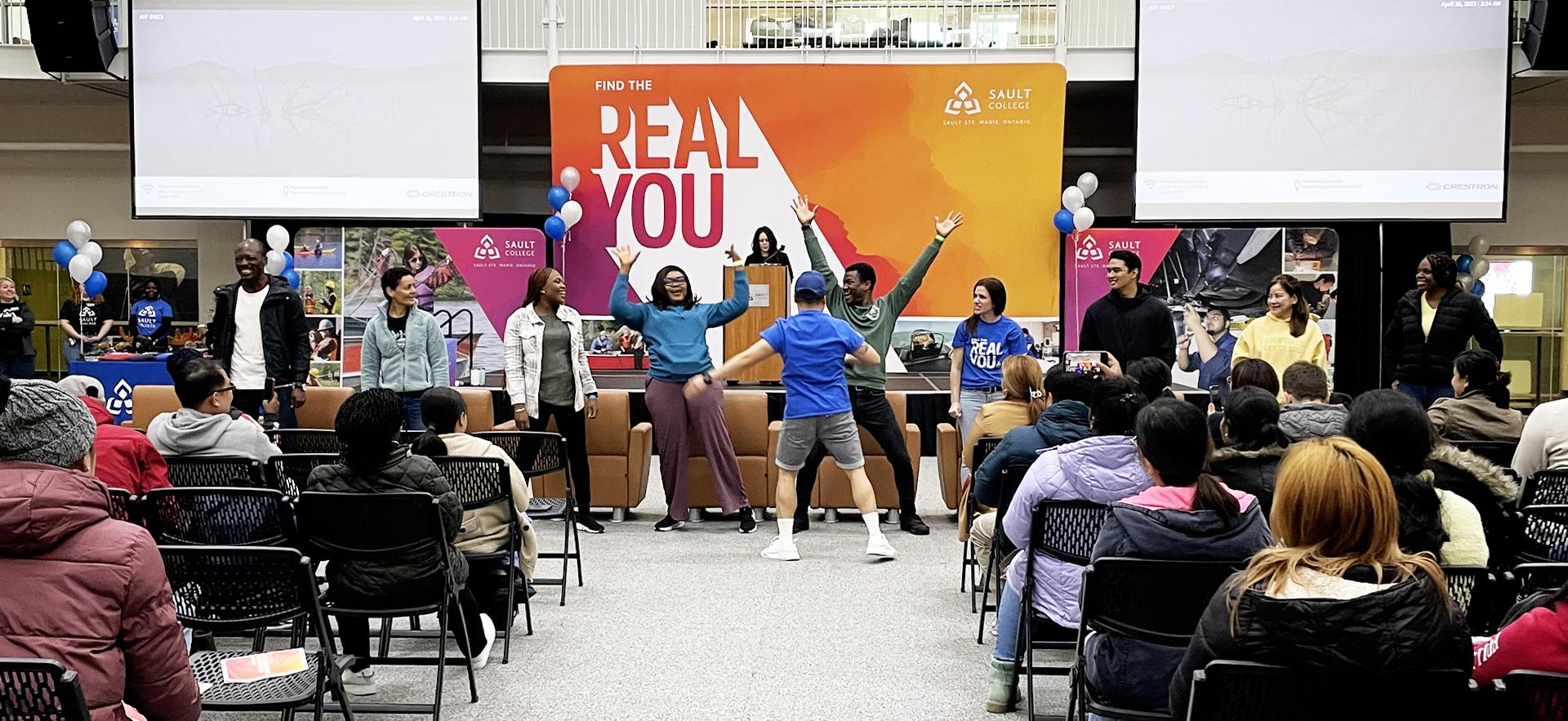 students in gym for International Orientation events with some students participating in a fun gam at the front