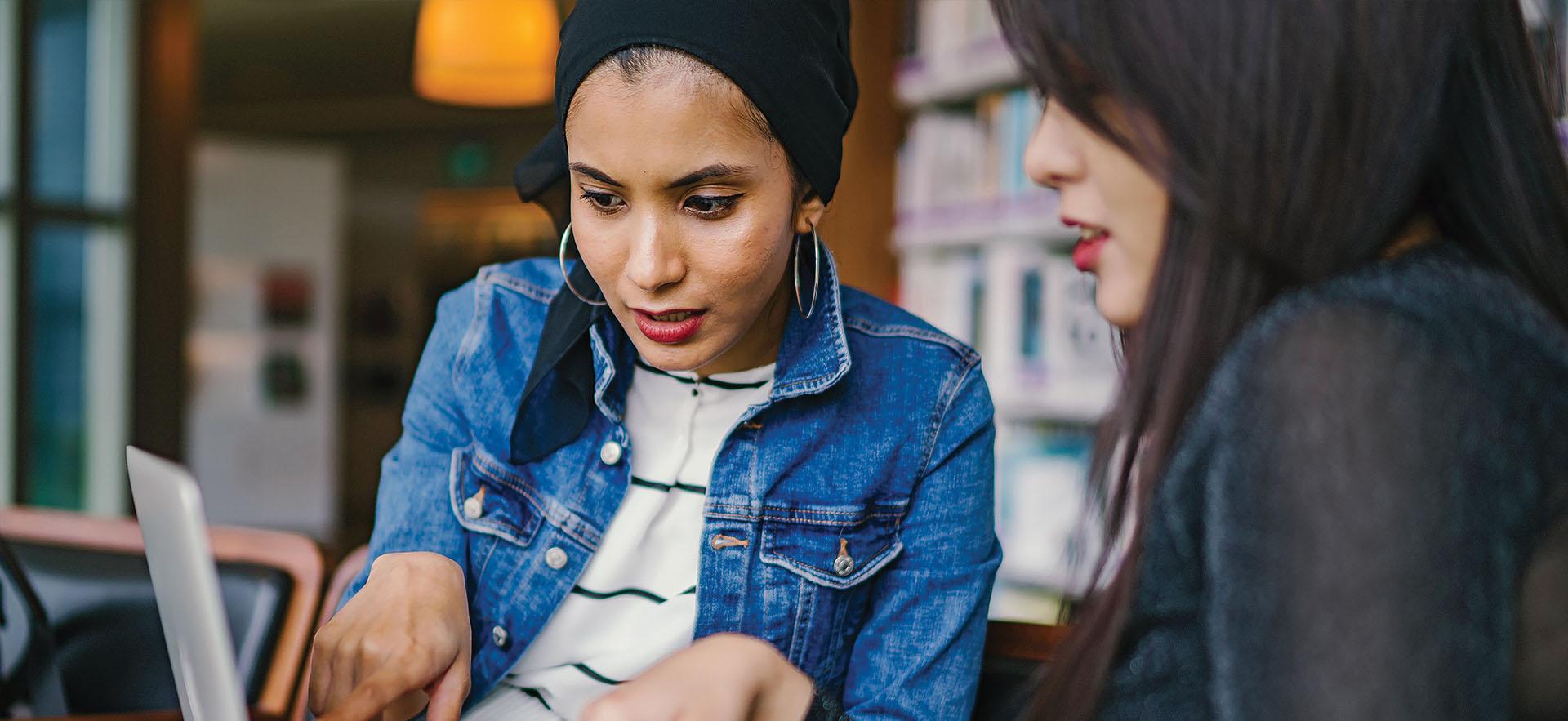 financial aid officer helping student in front of computer