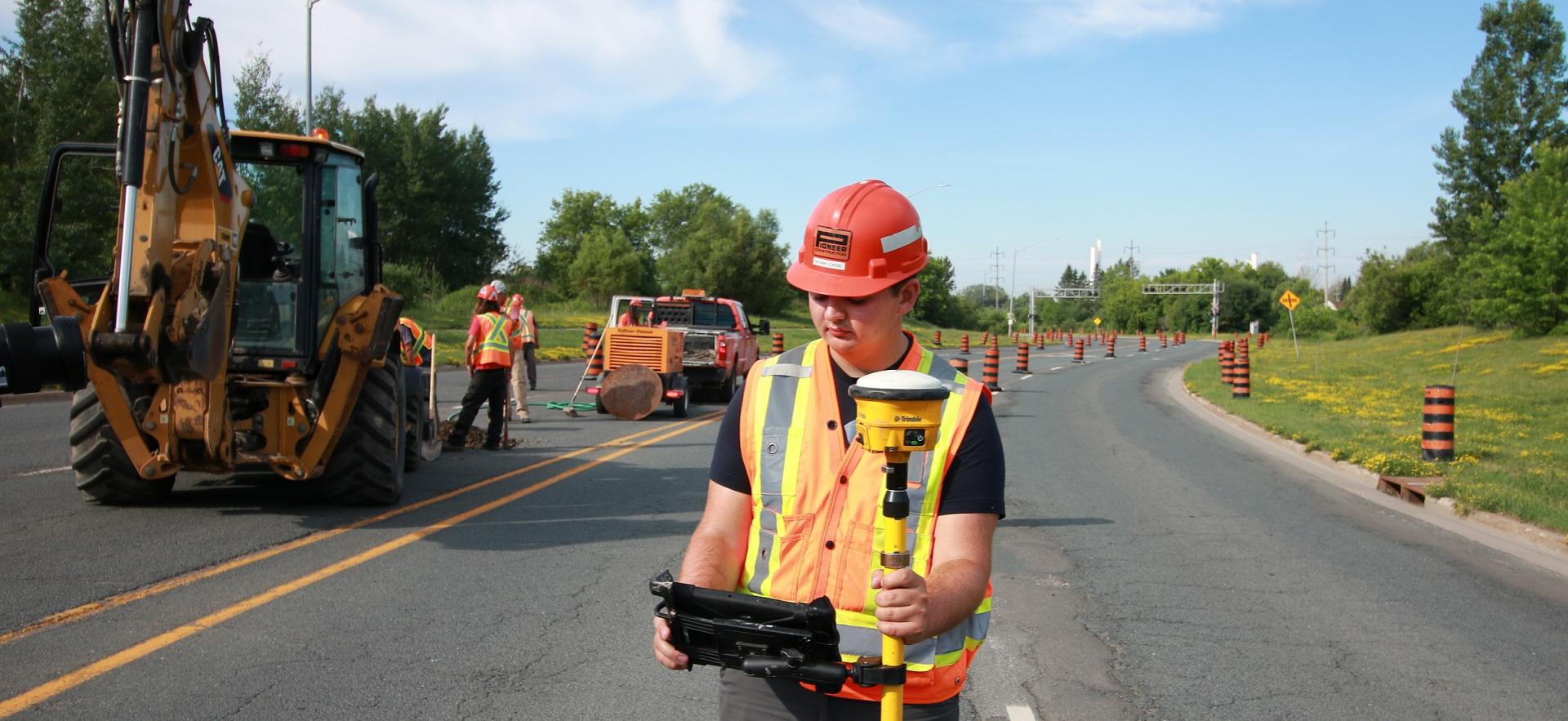 Civil Engineering Technician co-op student on the road working with a construction project 
