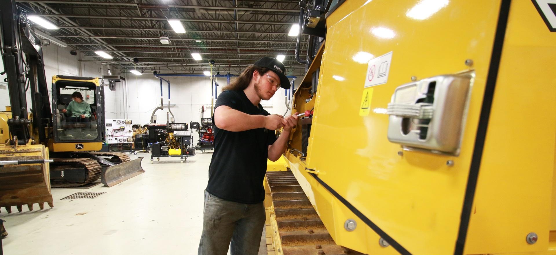 Heavy Equipment student fixing construction vehicle