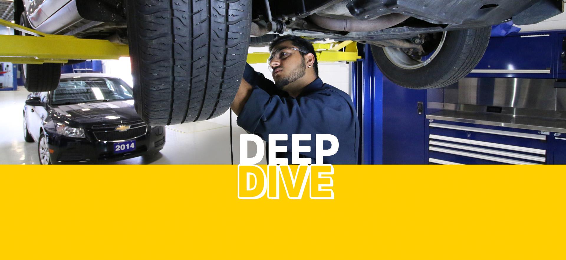 Deep Dive Skilled Trades student working under vehicle in automotive program