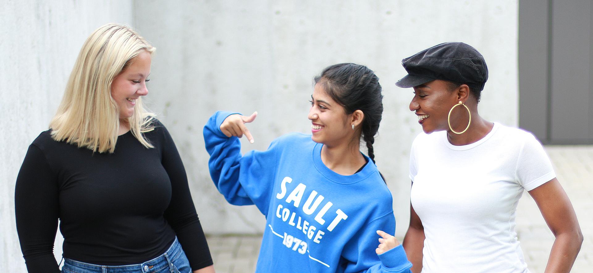 Three students smiling, talking and having fun