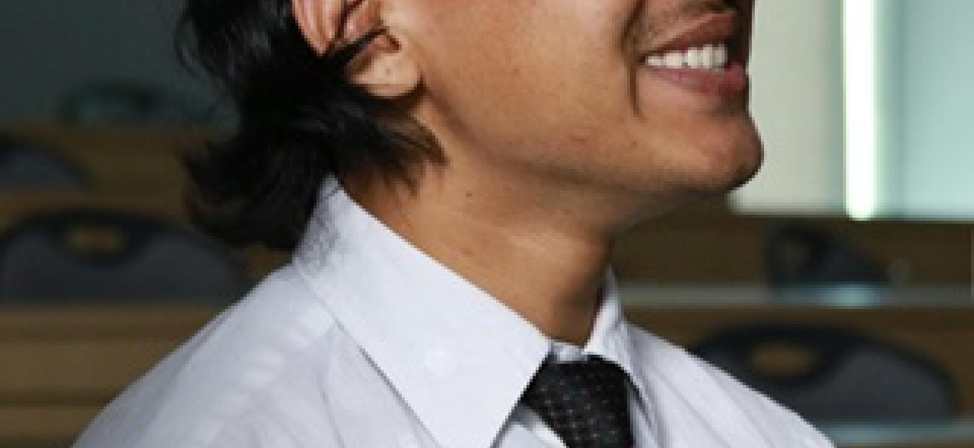 Business student in class smiling looking towards instructor off screen