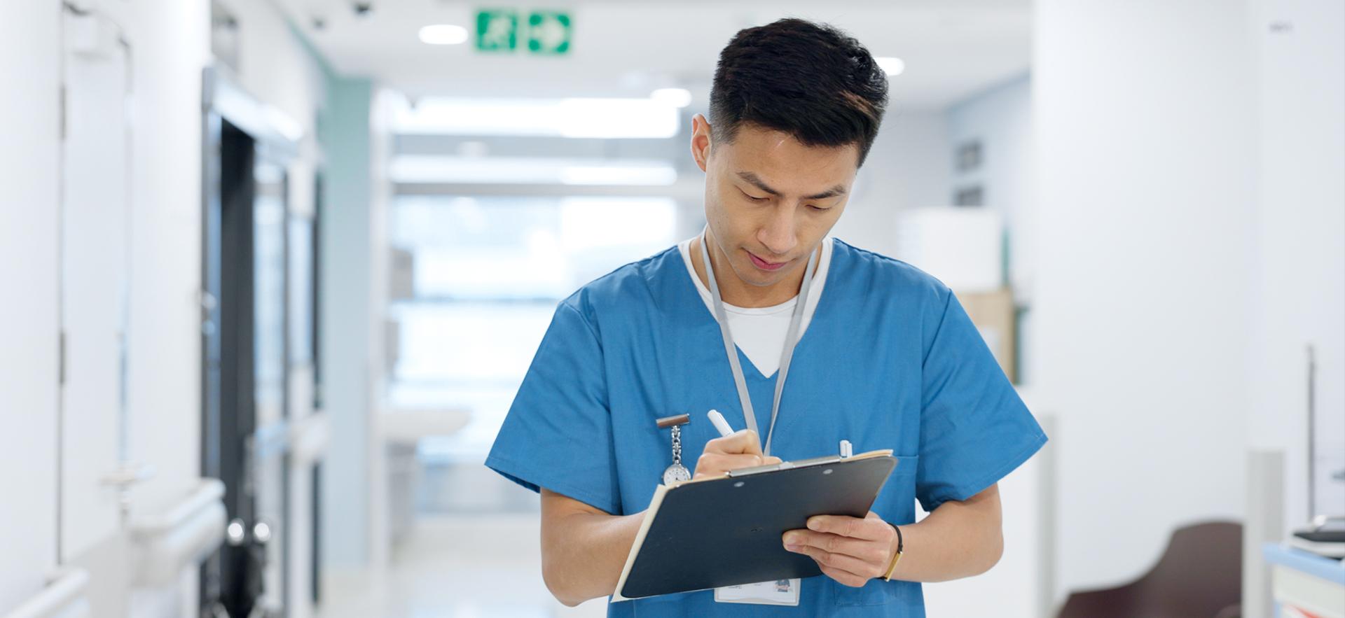 Nurse in hospital writing on clipboard