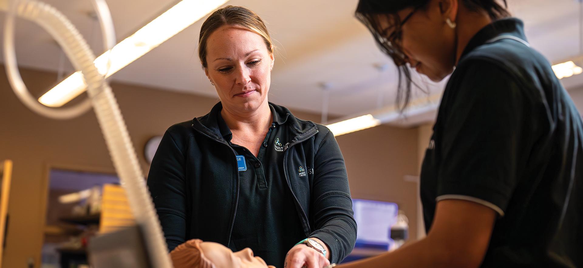 Practical Nursing students checking vitals of simulation manikin in sim lab