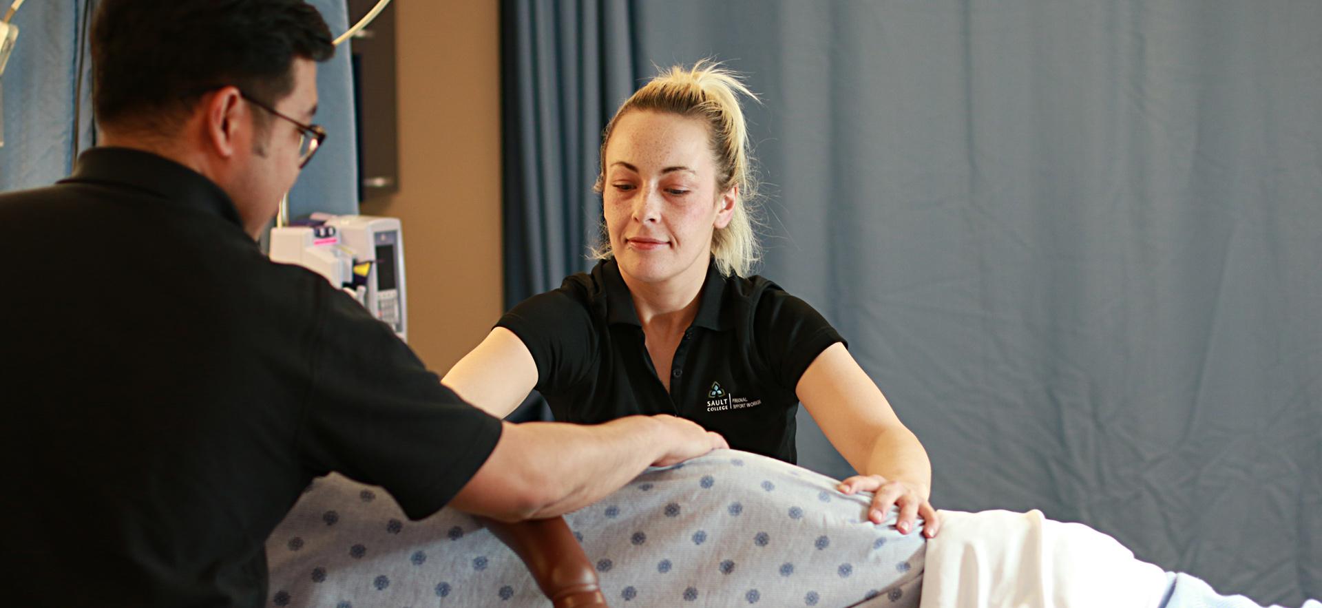 PSW students in the lab practicing skills moving a patient in bed