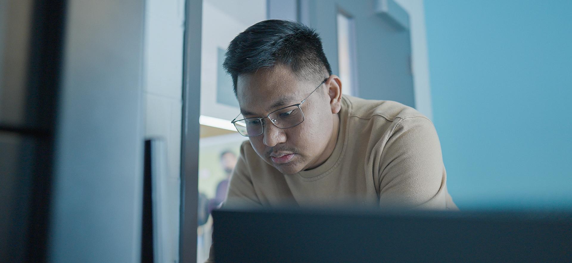 IT student working on the computer and stacks in the lab
