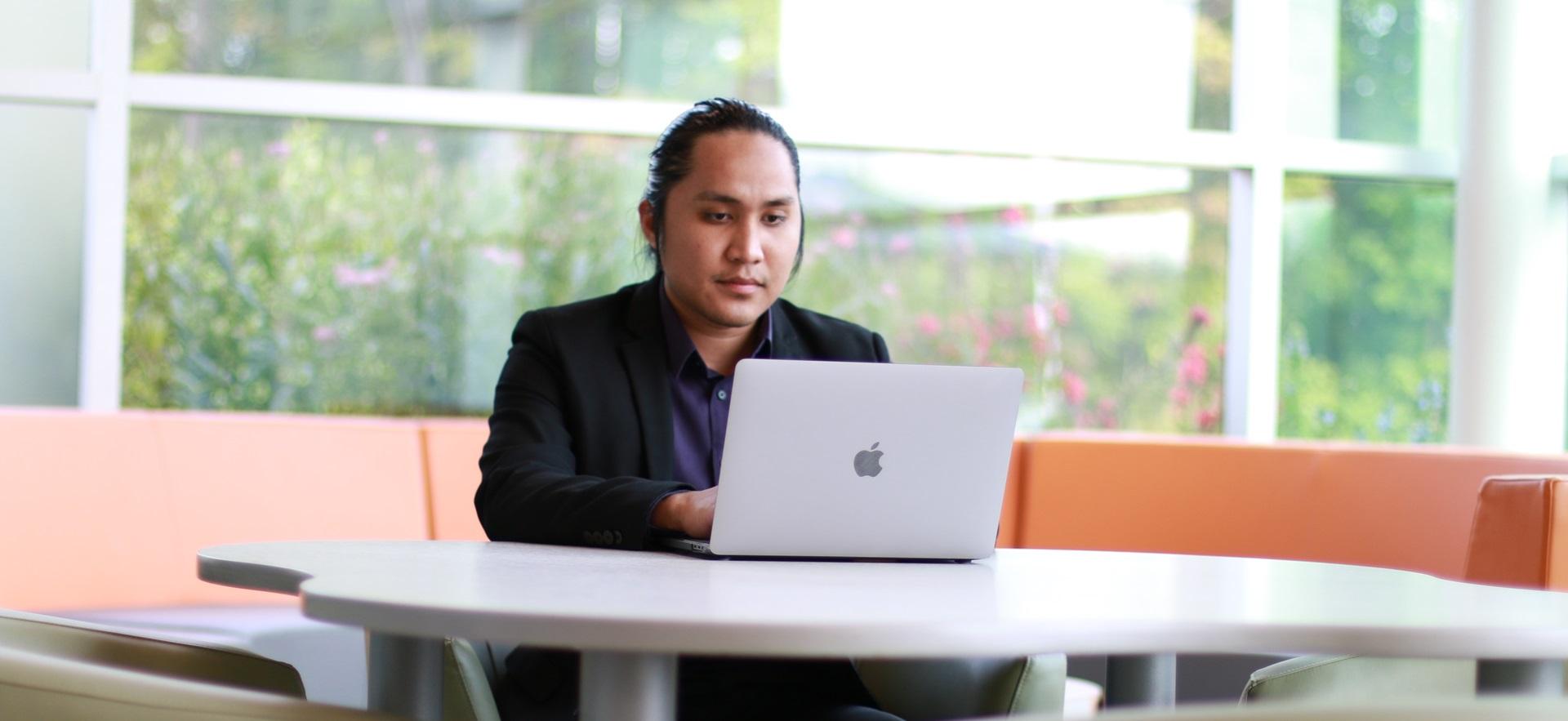 Business student working on the computer in a lounge area