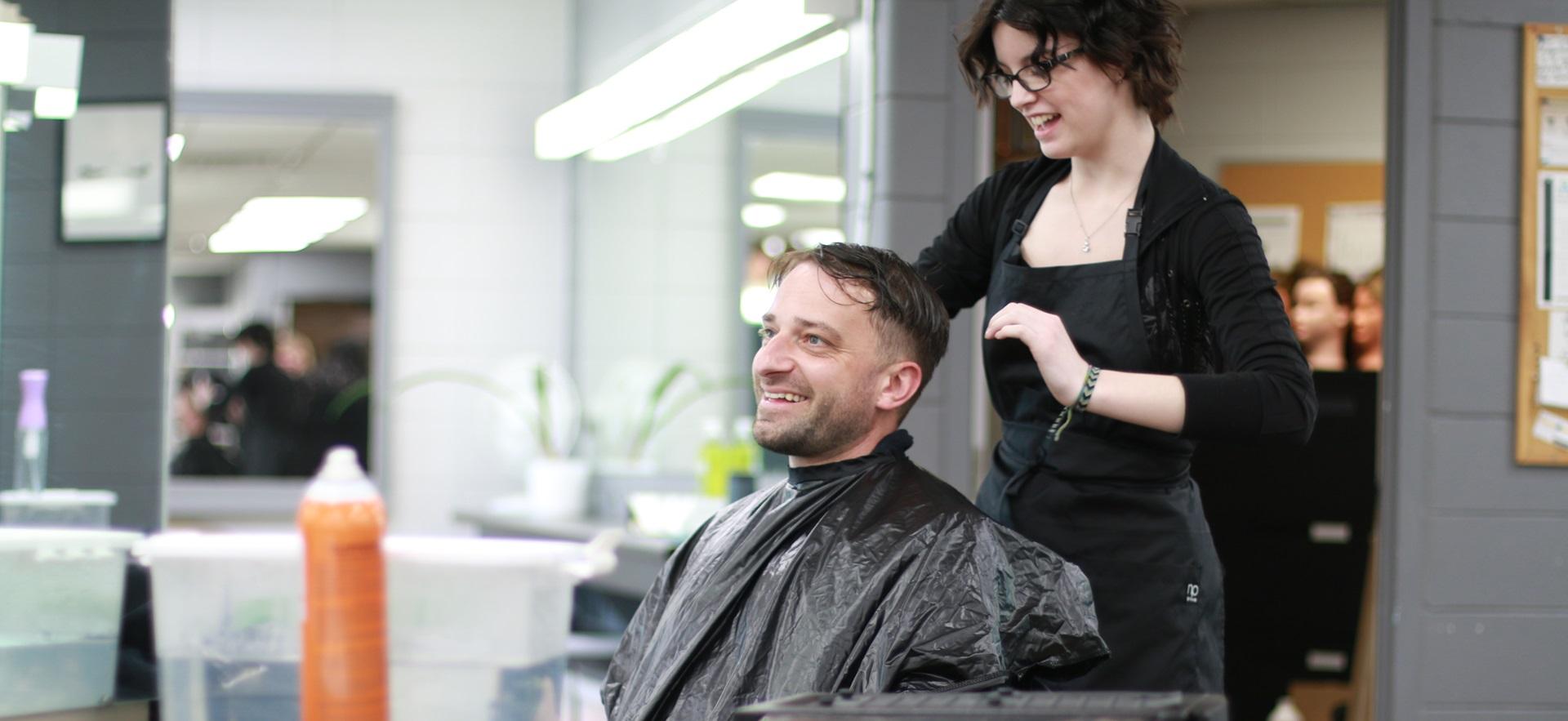 Hairstyling student doing client's hair in salon