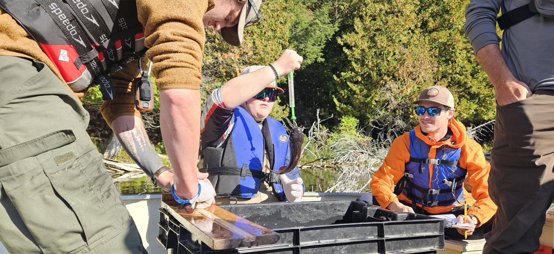 Fish and Wildlife students fishing on a boat in the lake