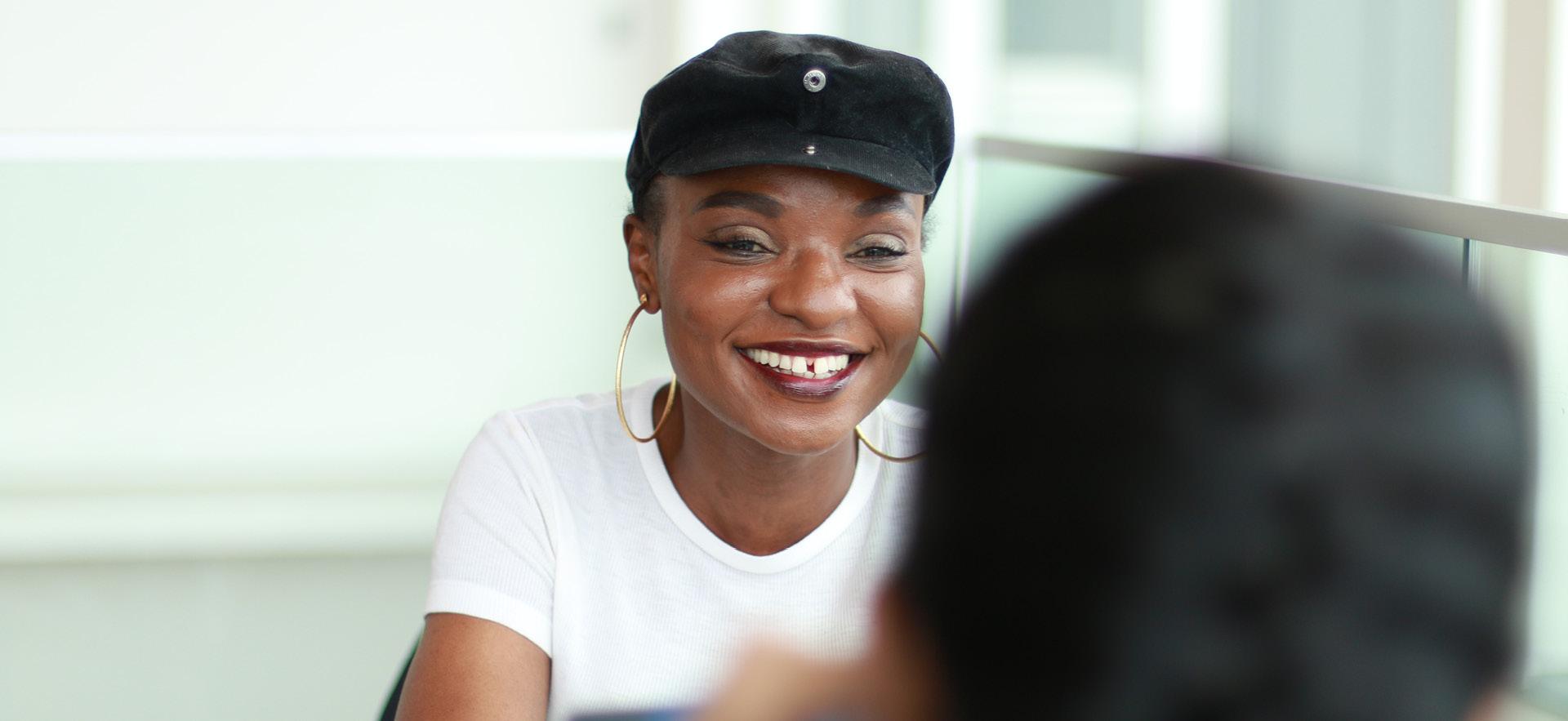 Student smiling sitting across from another student