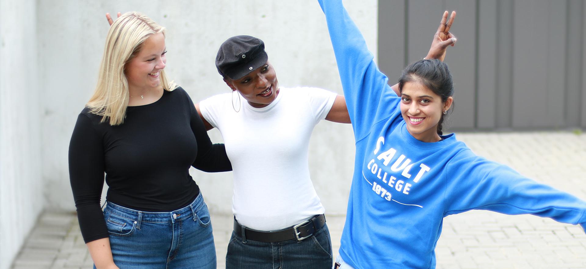 Three students having fun outside on campus