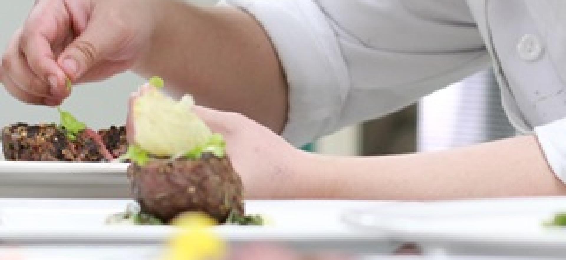 Culinary student plating a disk in the kitchen