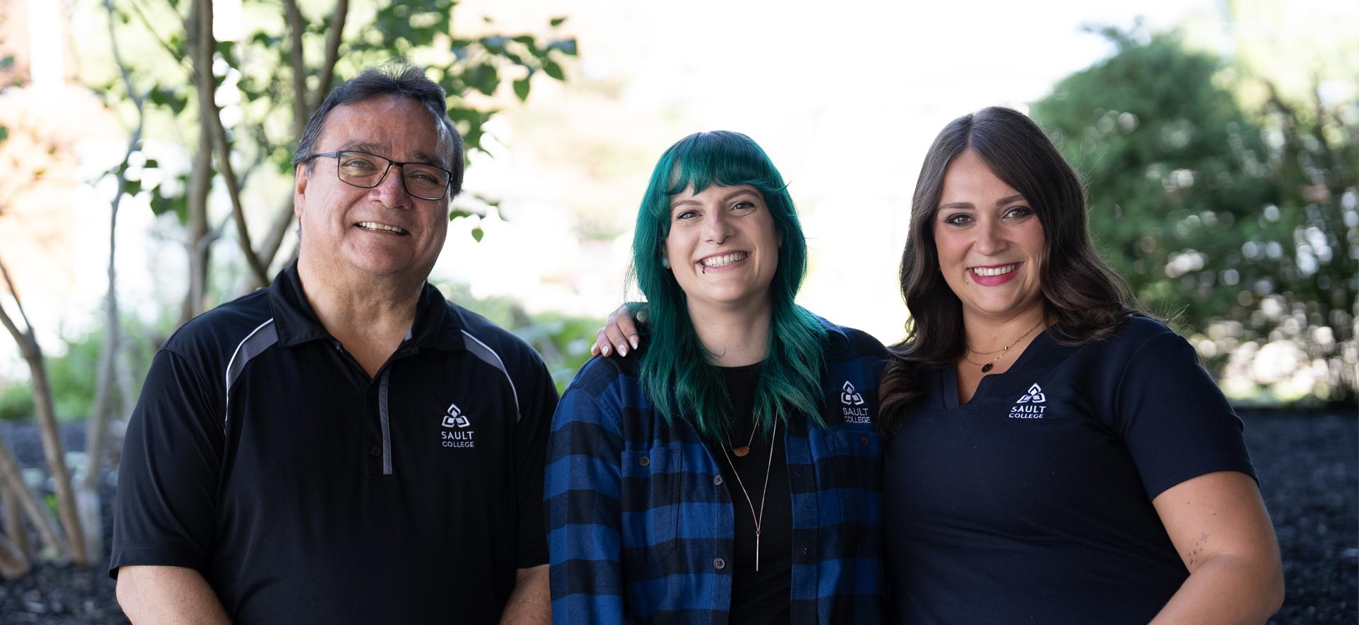 Three recruiters standing together smiling