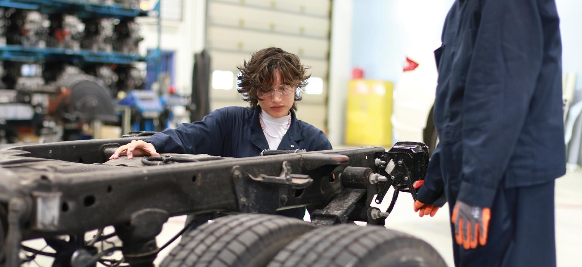 Automotive student working on heavy equipment in the lab