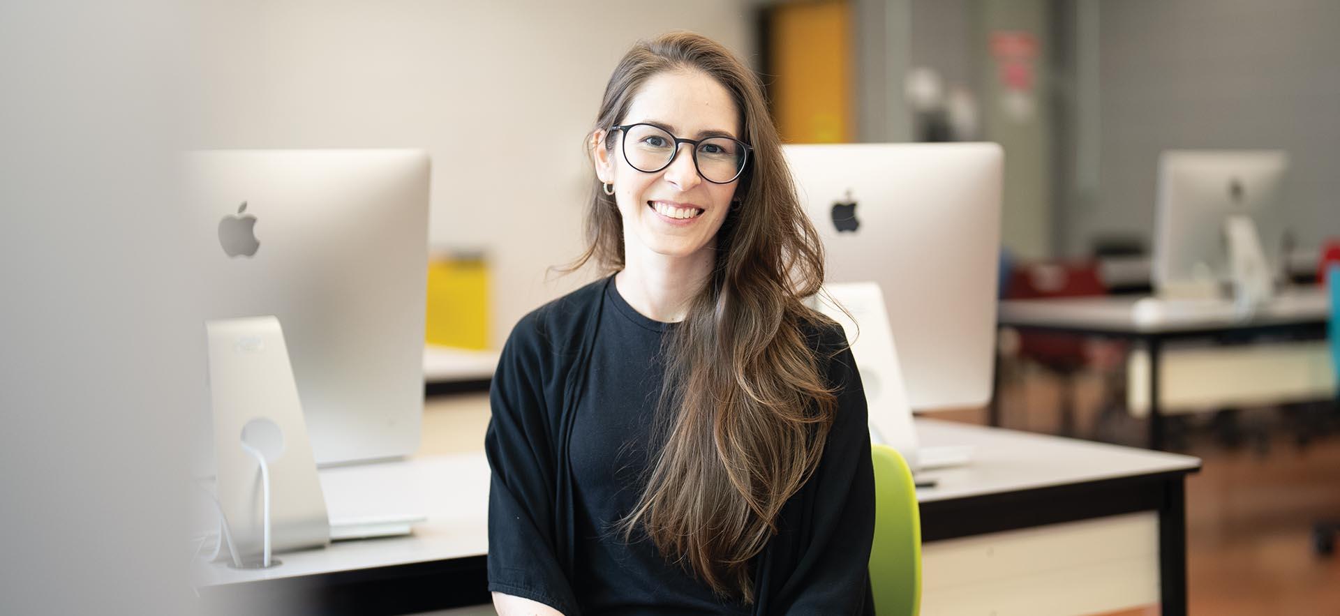 Graphic Design student smiling in Mac computer lab