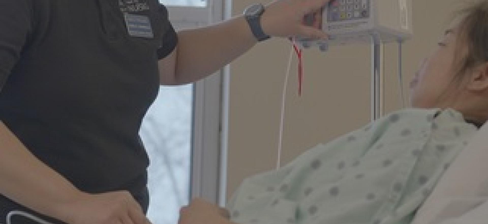 Nursing student in lab practicing vitals and IV with a classmate as patient