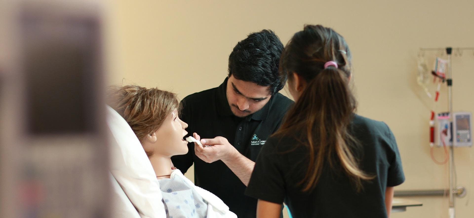 PSW students in the lab brushing the teeth of a mannequin patient