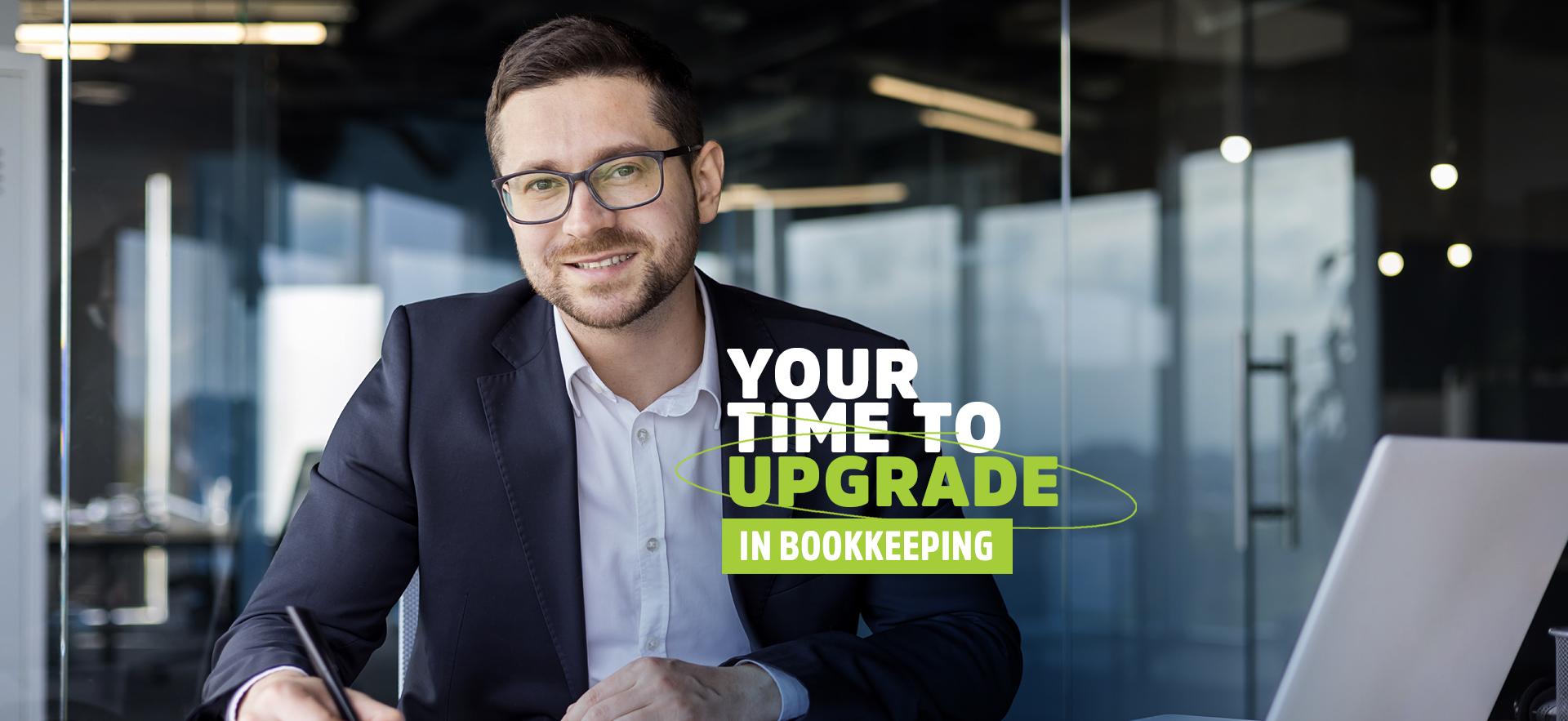 Man at desk smiling at camera for upgrading in bookkeeping