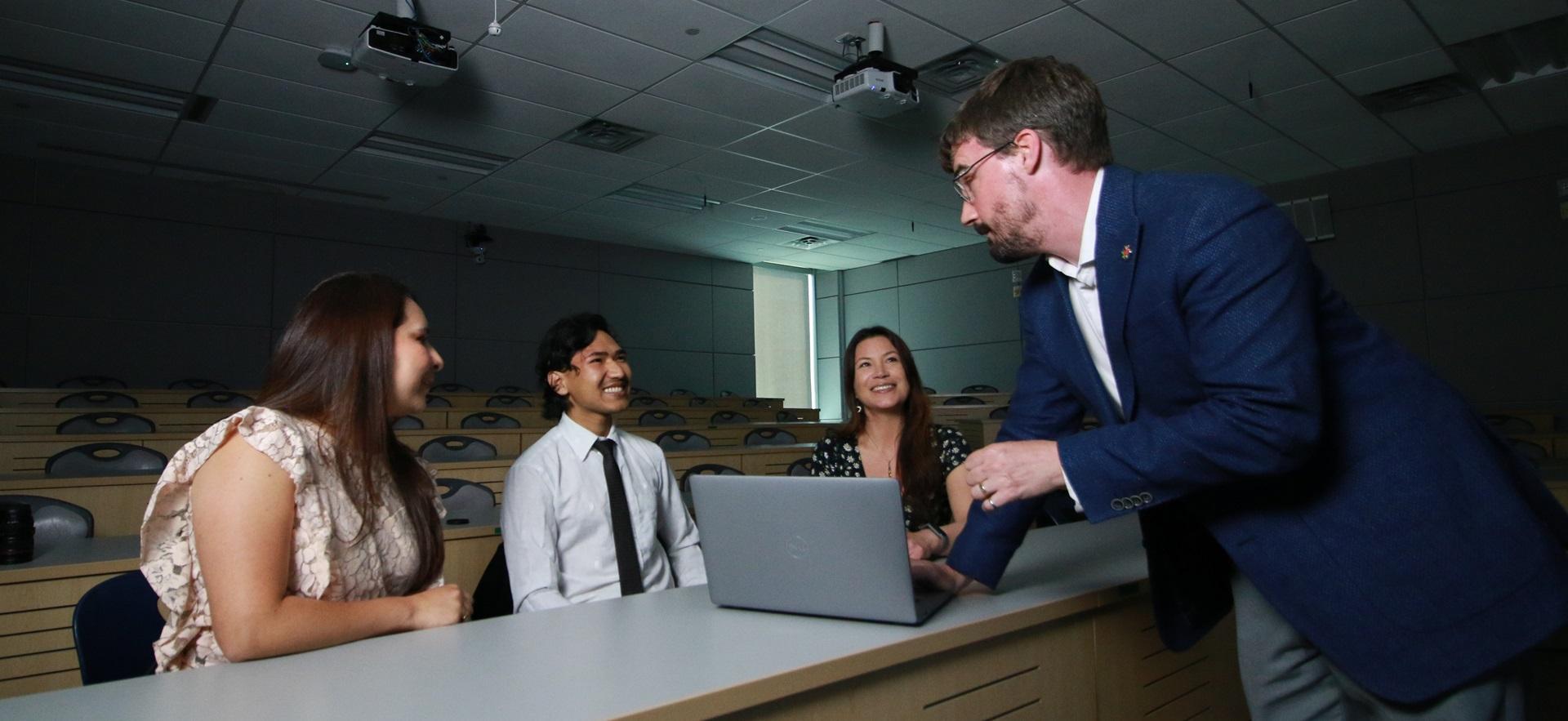 Business faculty with students in multimedia room for presentation