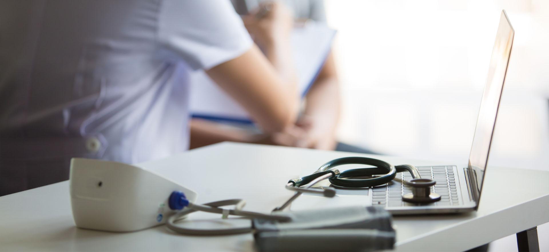 Health centre showing nurse sitting with a person and medical tools on table
