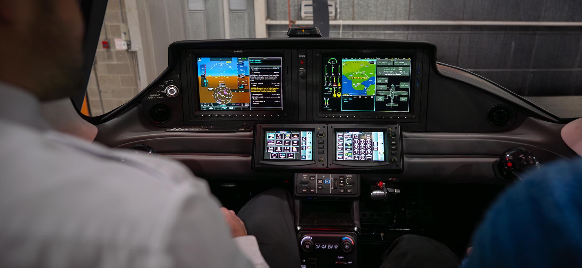 Aviation student shoulder shown to view split flight screen inside Cirrus aircraft