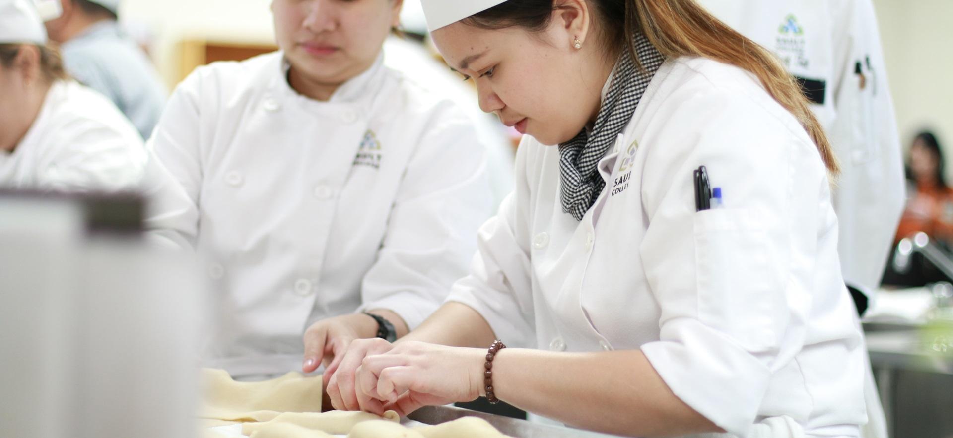 Culinary student rolling pastry in pan