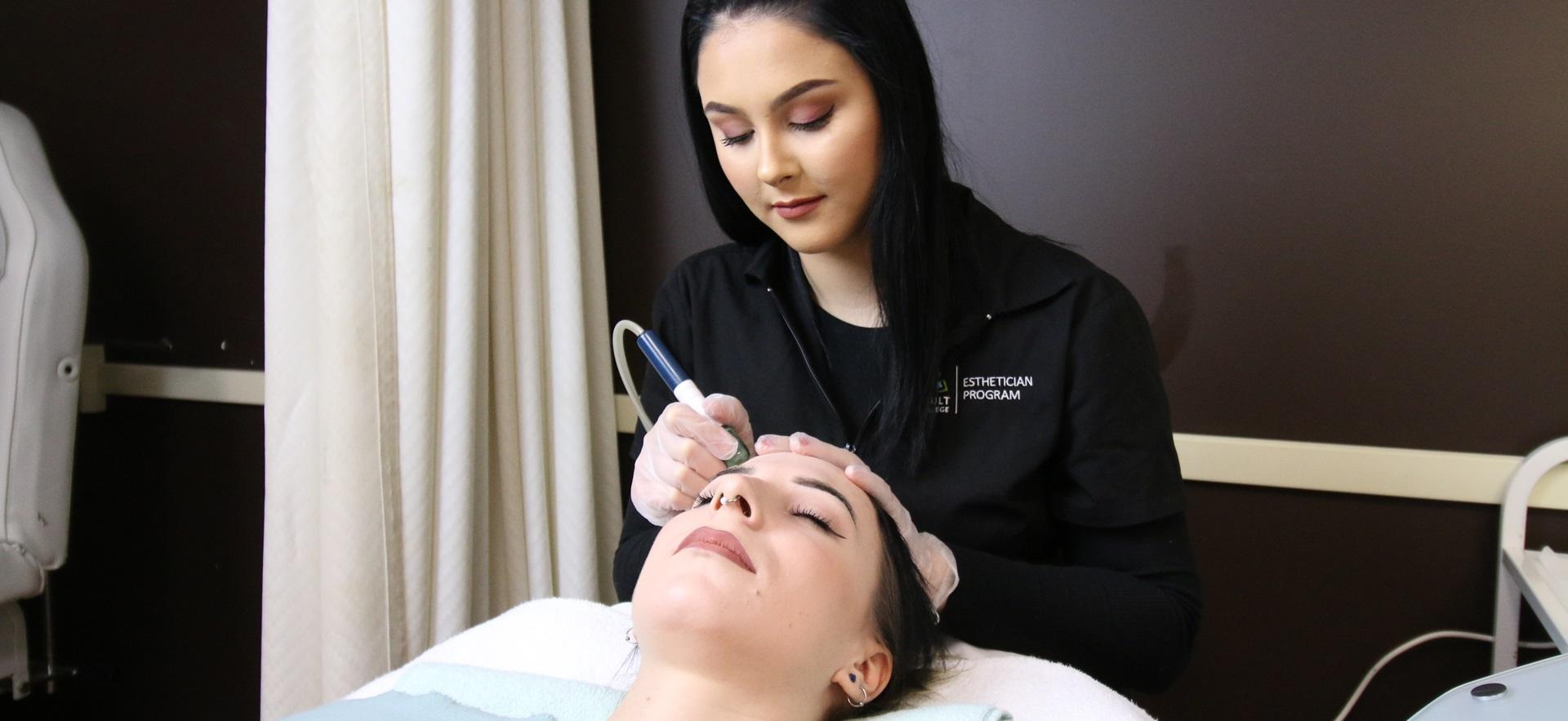 Esthetician student completing facial procedure on classmate