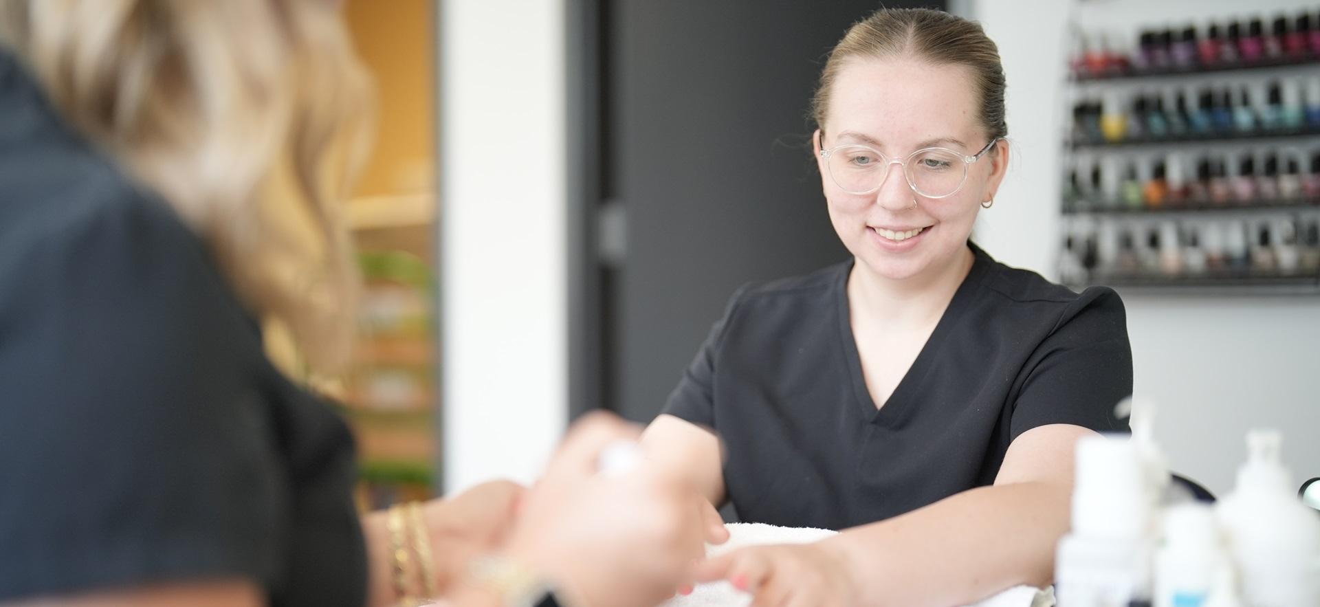 Esthetician student giving a manicure to classmate