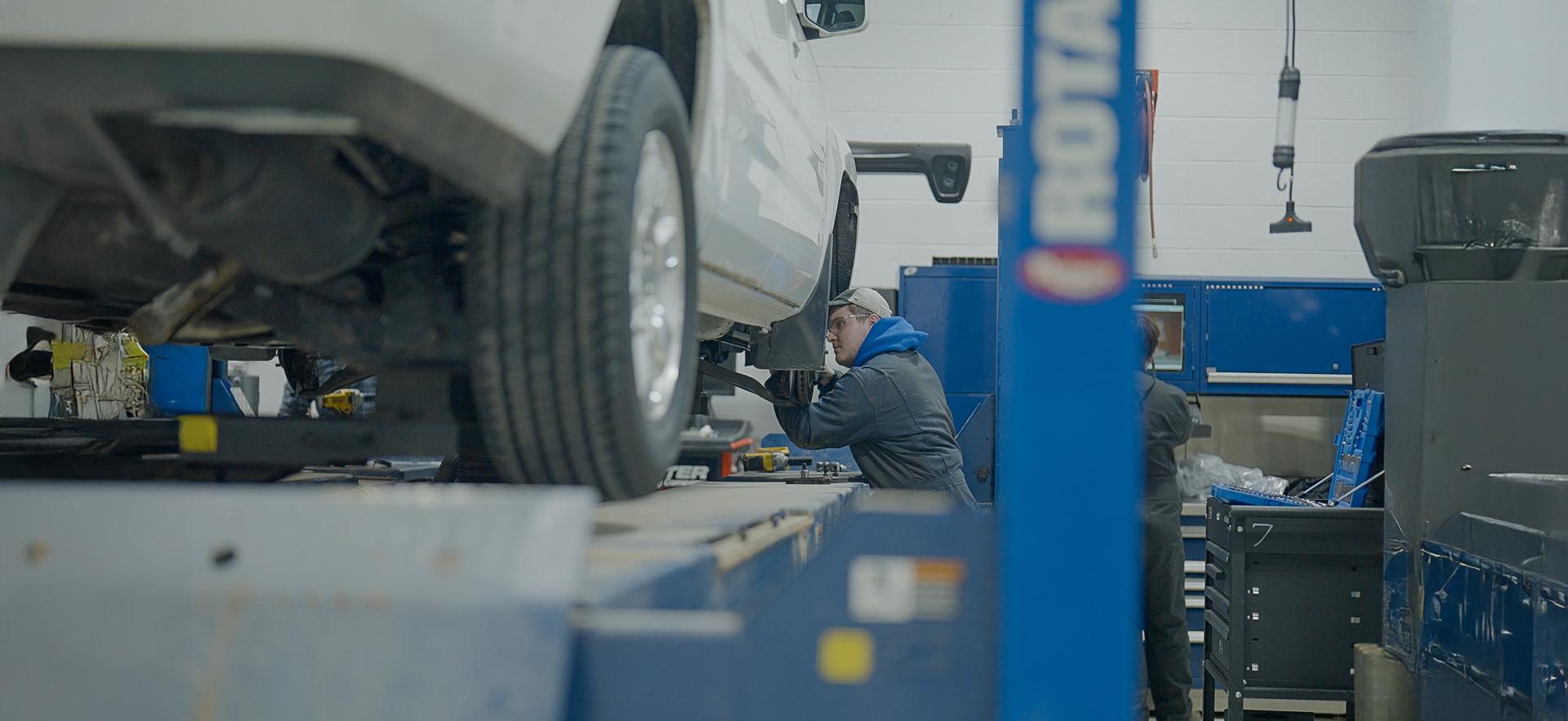 CICE student looking under car in motive power centre