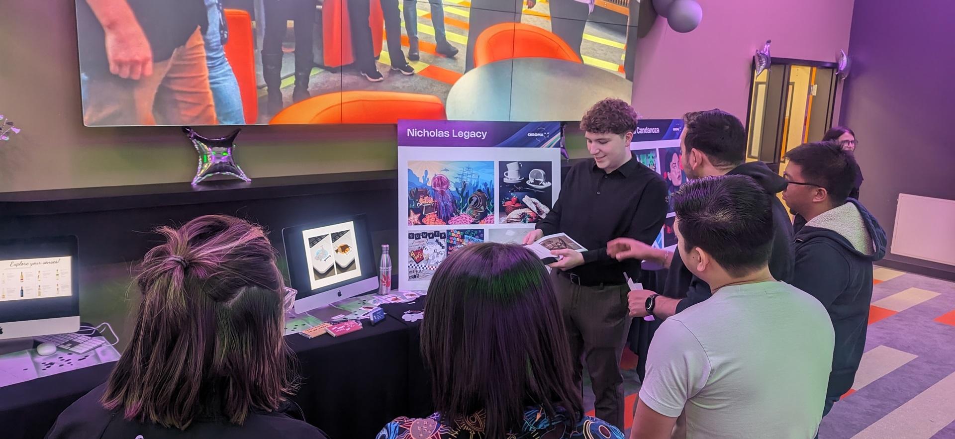 Graphic Design graduate exhibit with student showing his work
