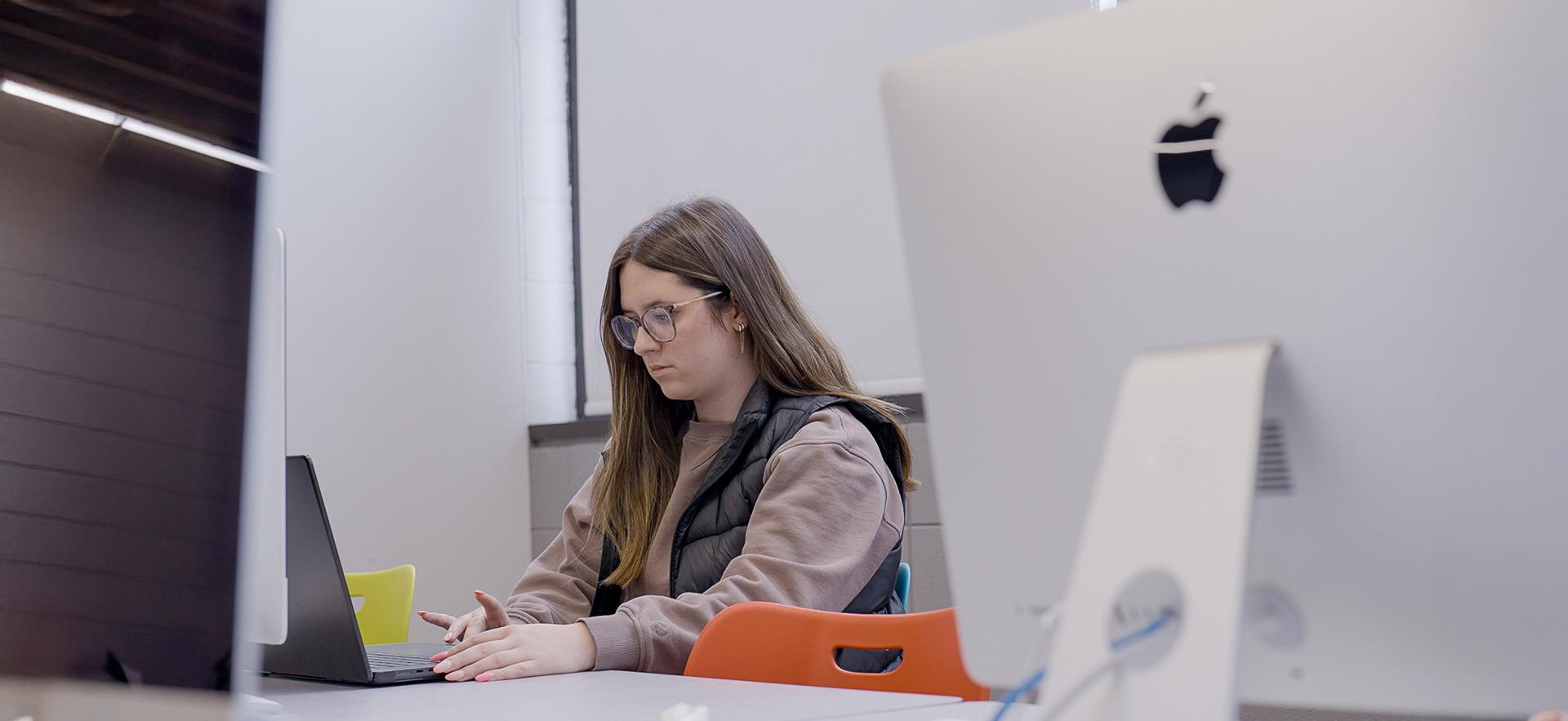 Graphic Design student working on Mac in lab