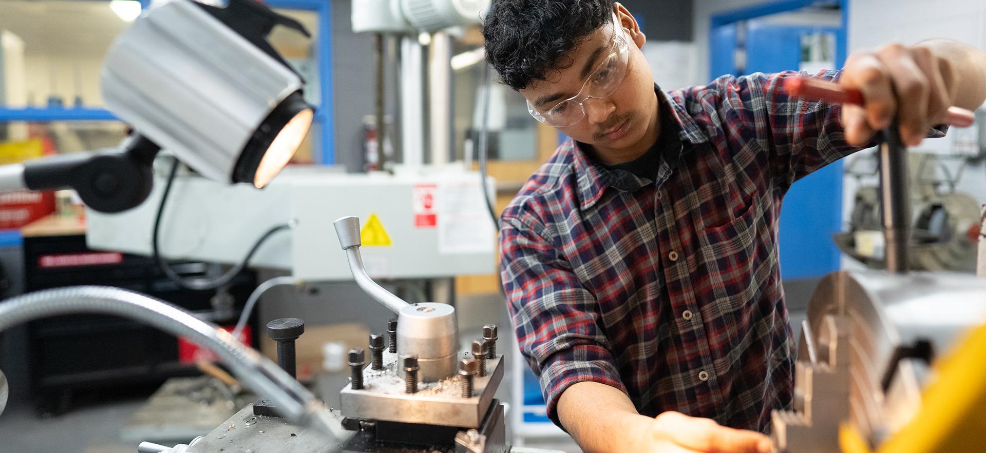 Student working with equipment in the machine shop