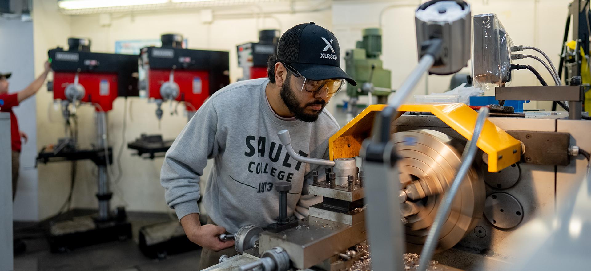 Student working with equipment in the machine shop