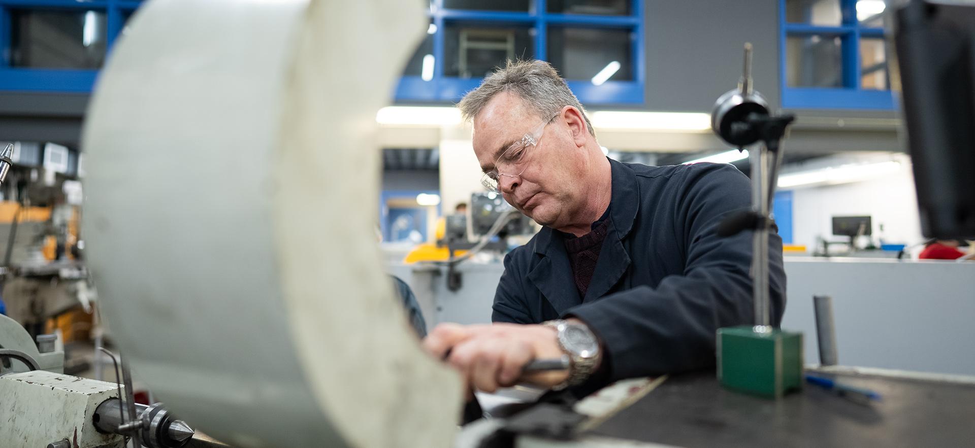 Instructor working with equipment in the machine shop