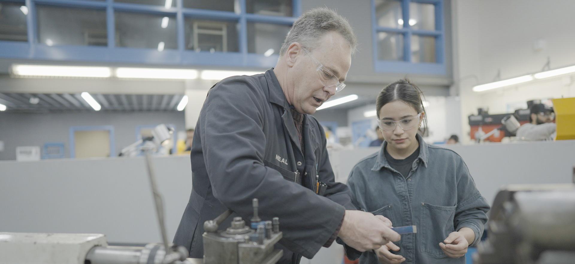Student and instructor working with equipment in the machine shop