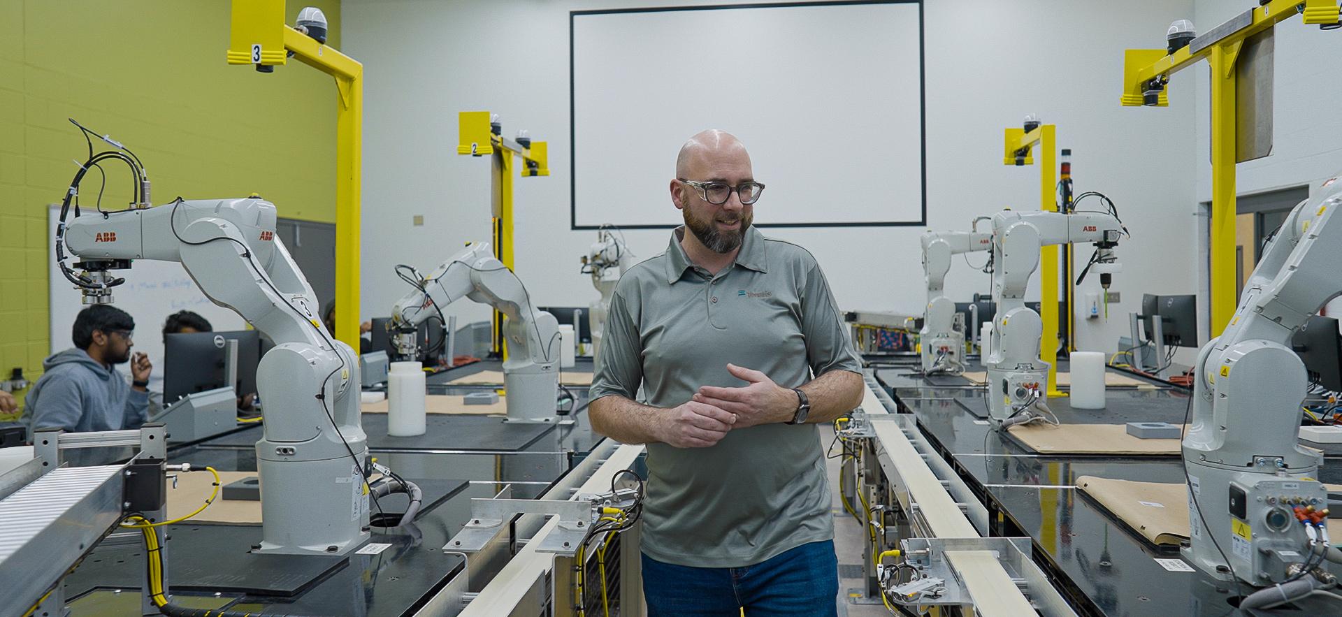 Engineering instructor walking through robotics lab
