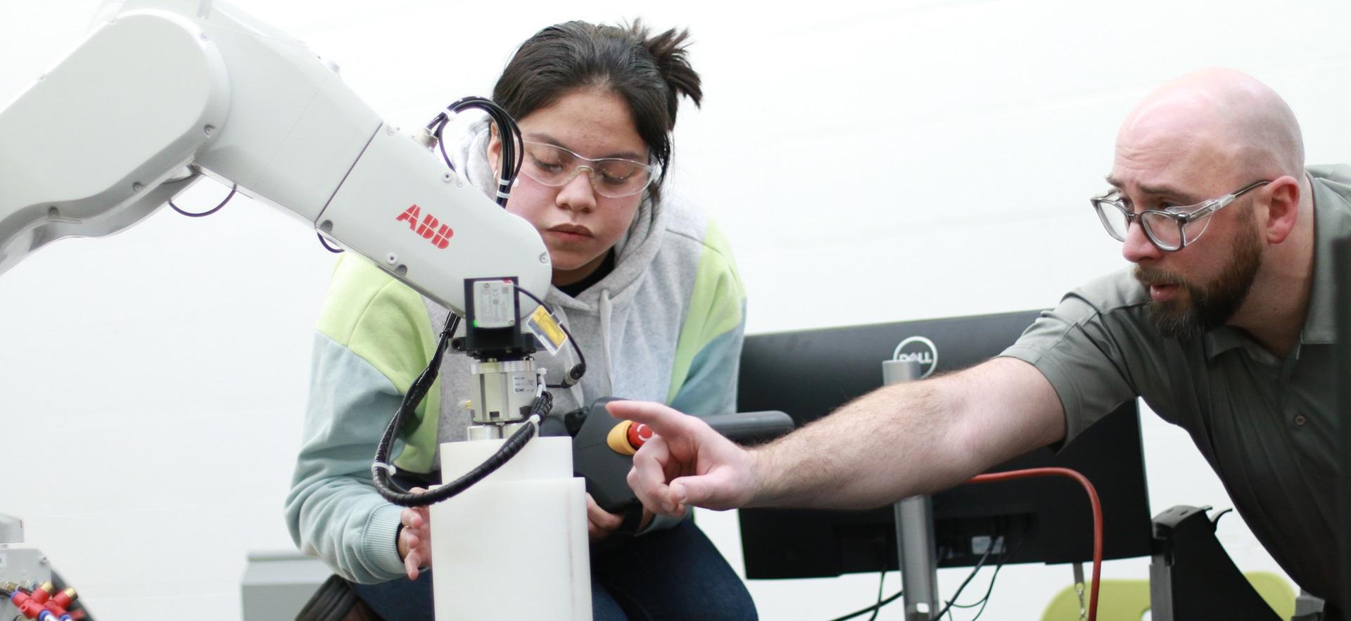 Engineering student getting feedback from instructor in robotics lab