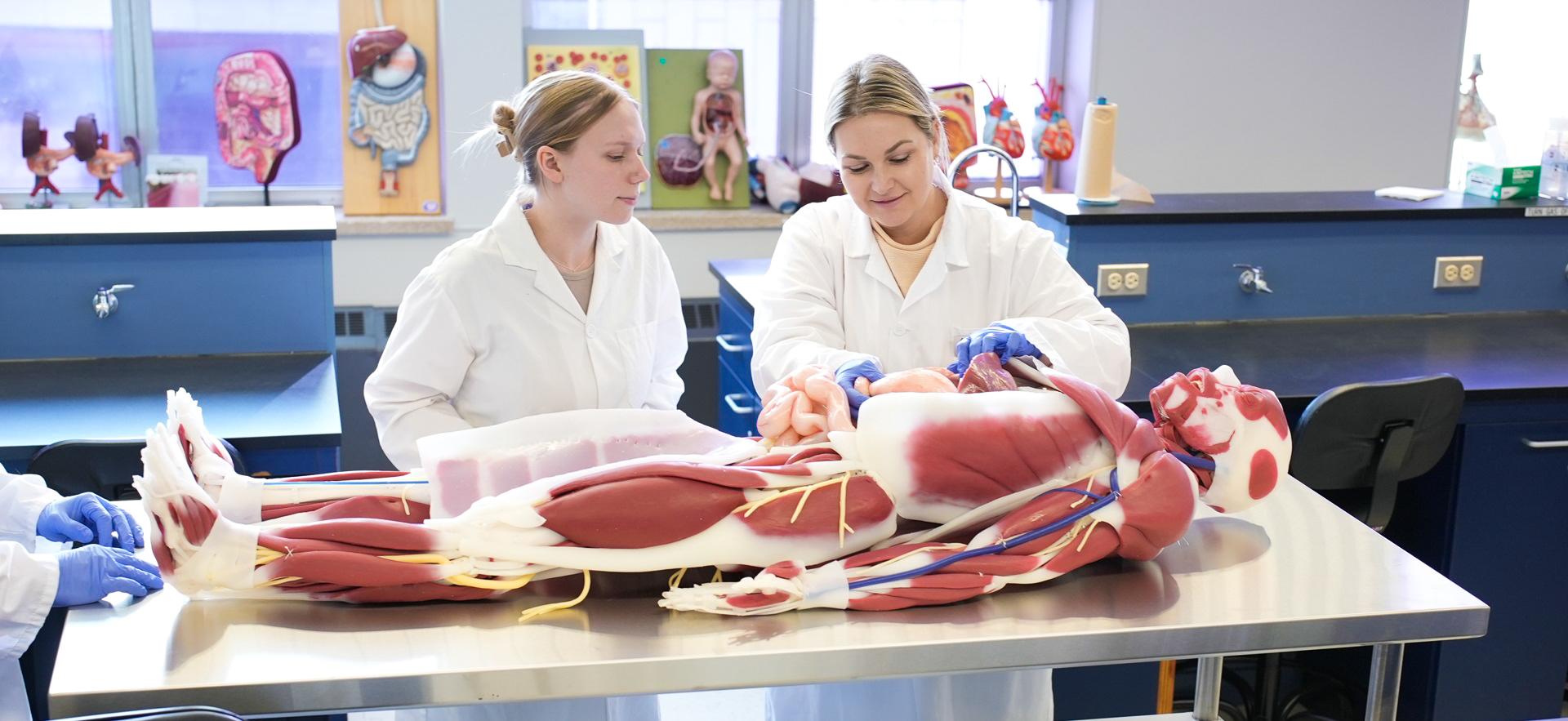 Nursing student with instructor exploring new manikin