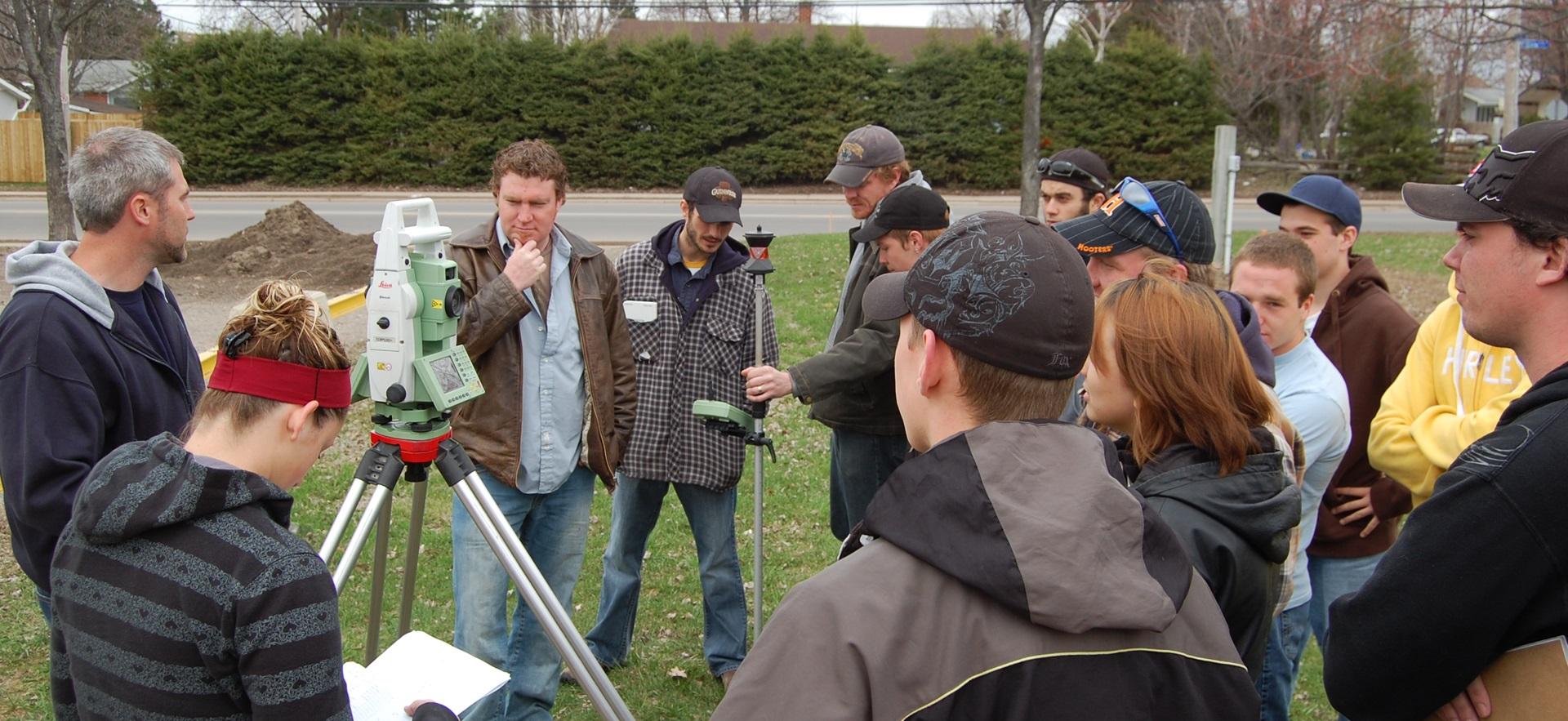 Civil Engineering students outside with a metre