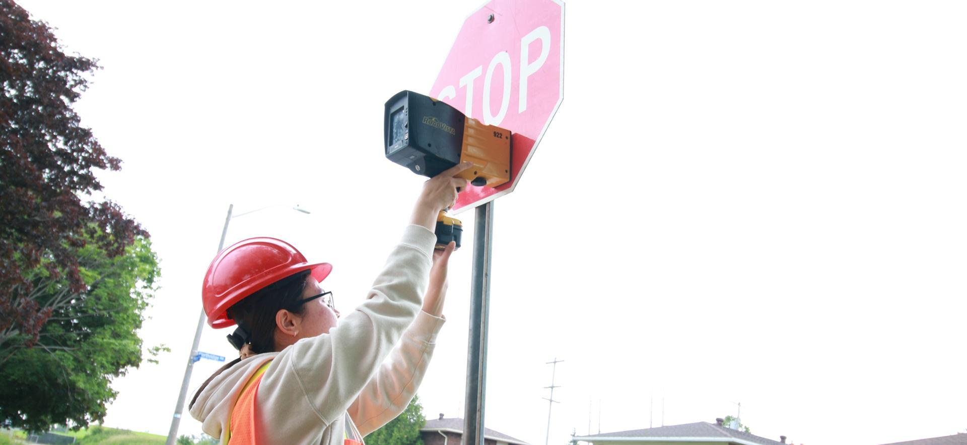 Civil Engineering student outside checking stop sign