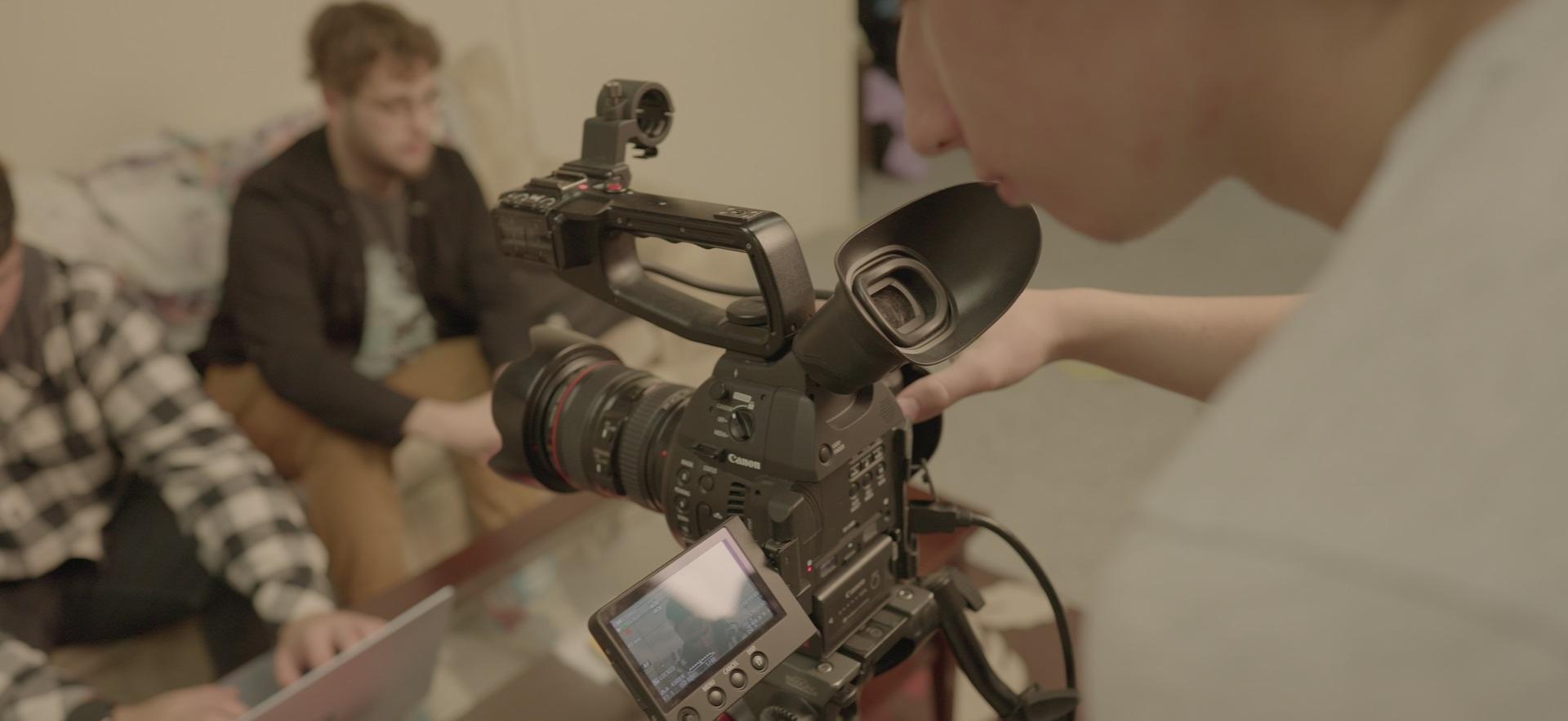 Film student filming classmates on set