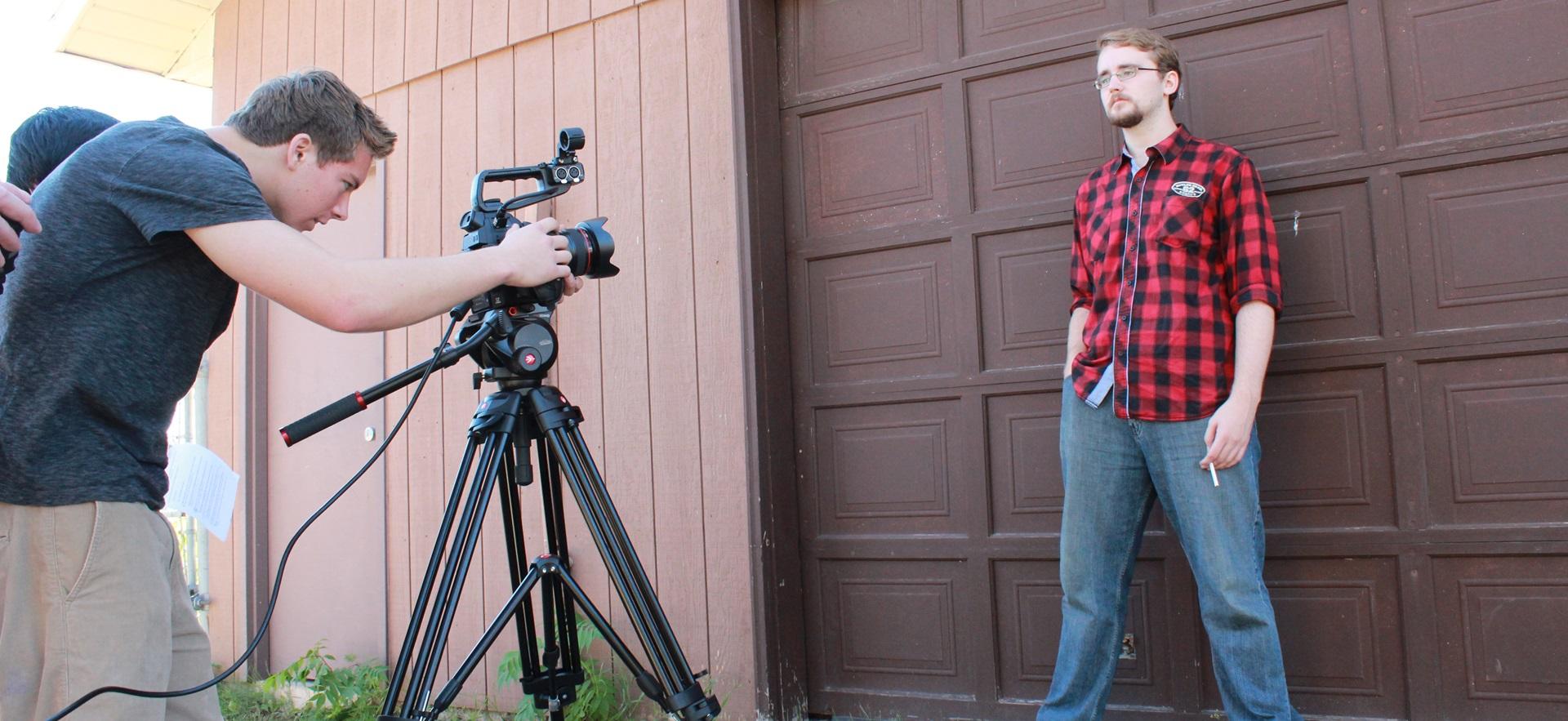 Film student controlling camera recording for a production outdoors