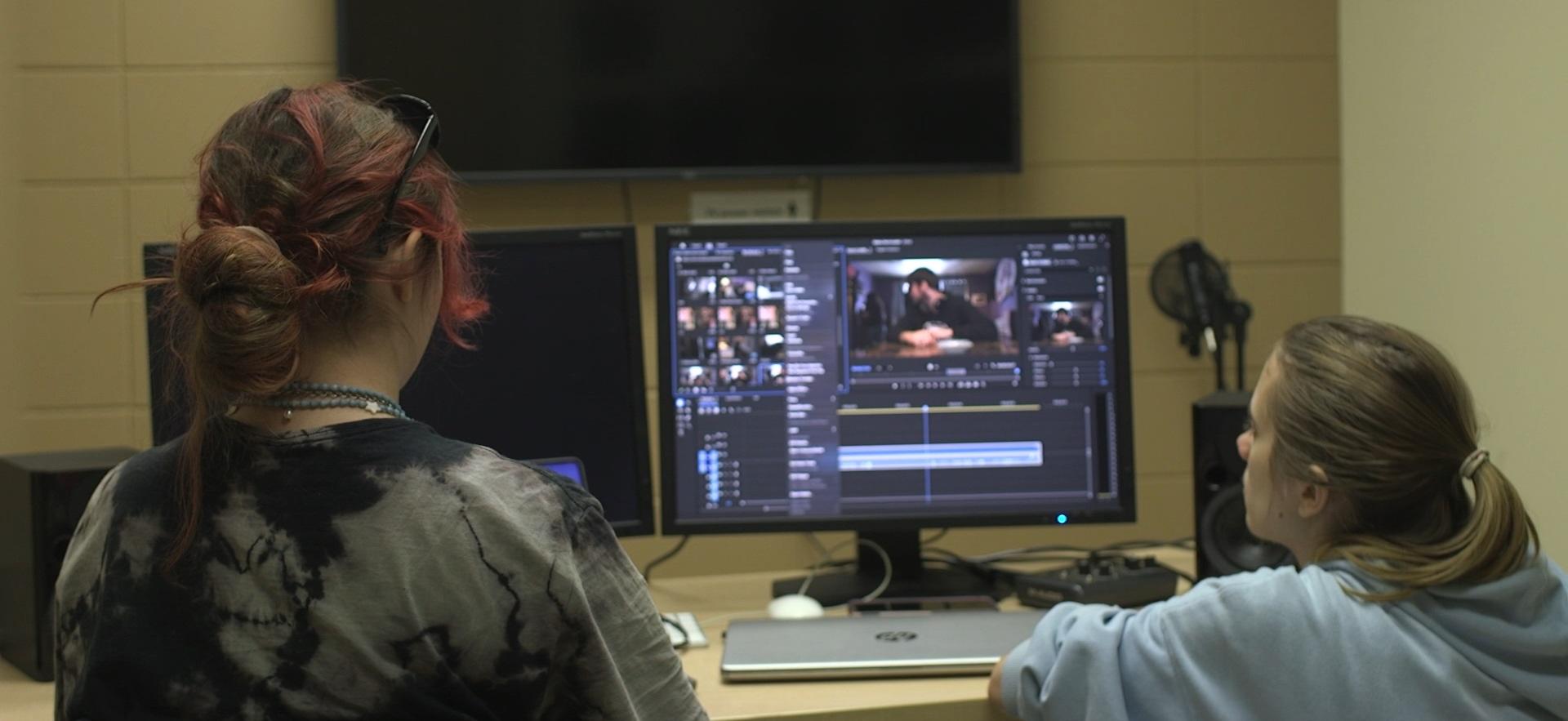 Film students looking at computer for editing film