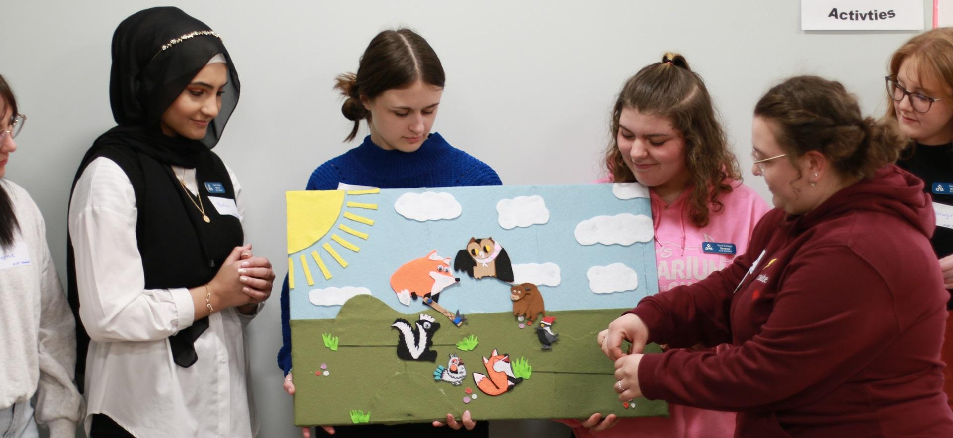ECE students looking at felt animal scene board and moving things on it