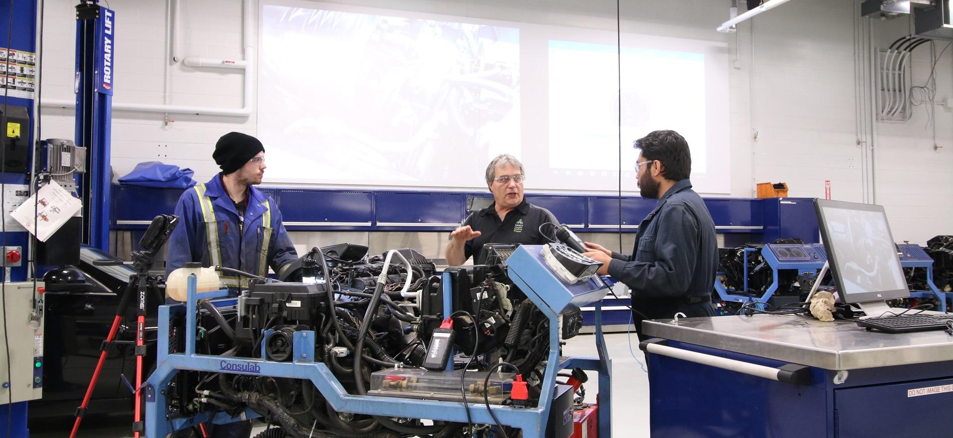 Motive Power students with instructor working on parts through video