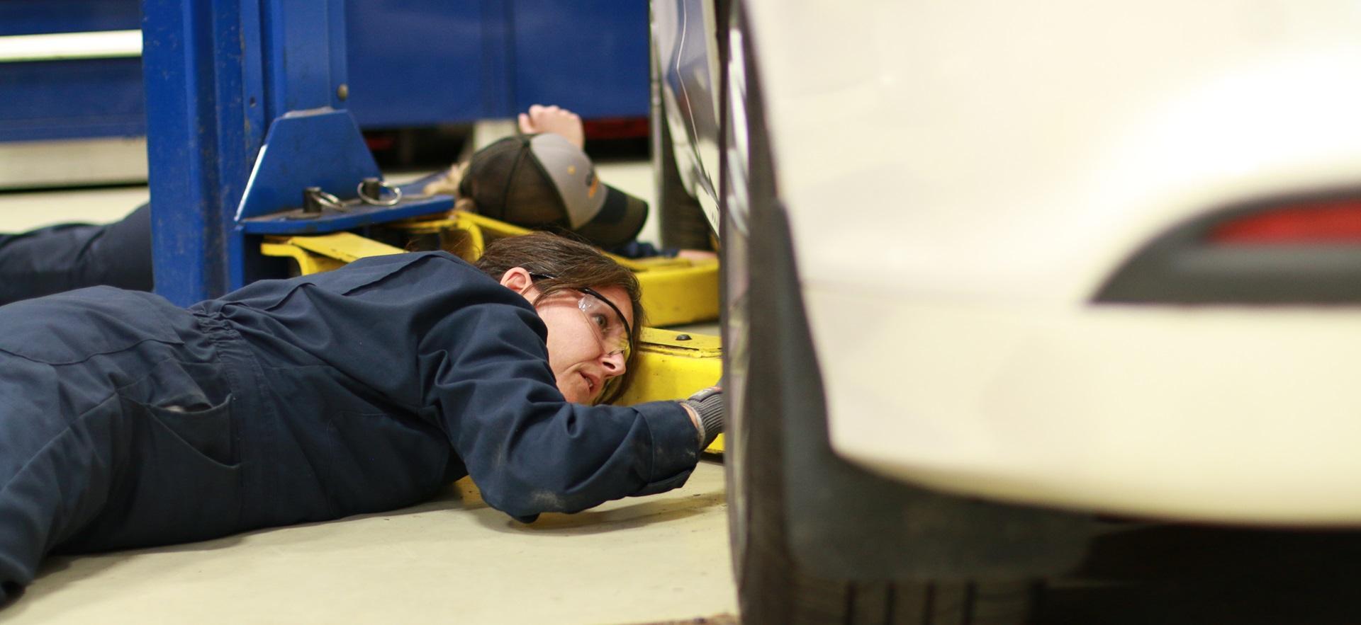 Motive Power student looking under a car
